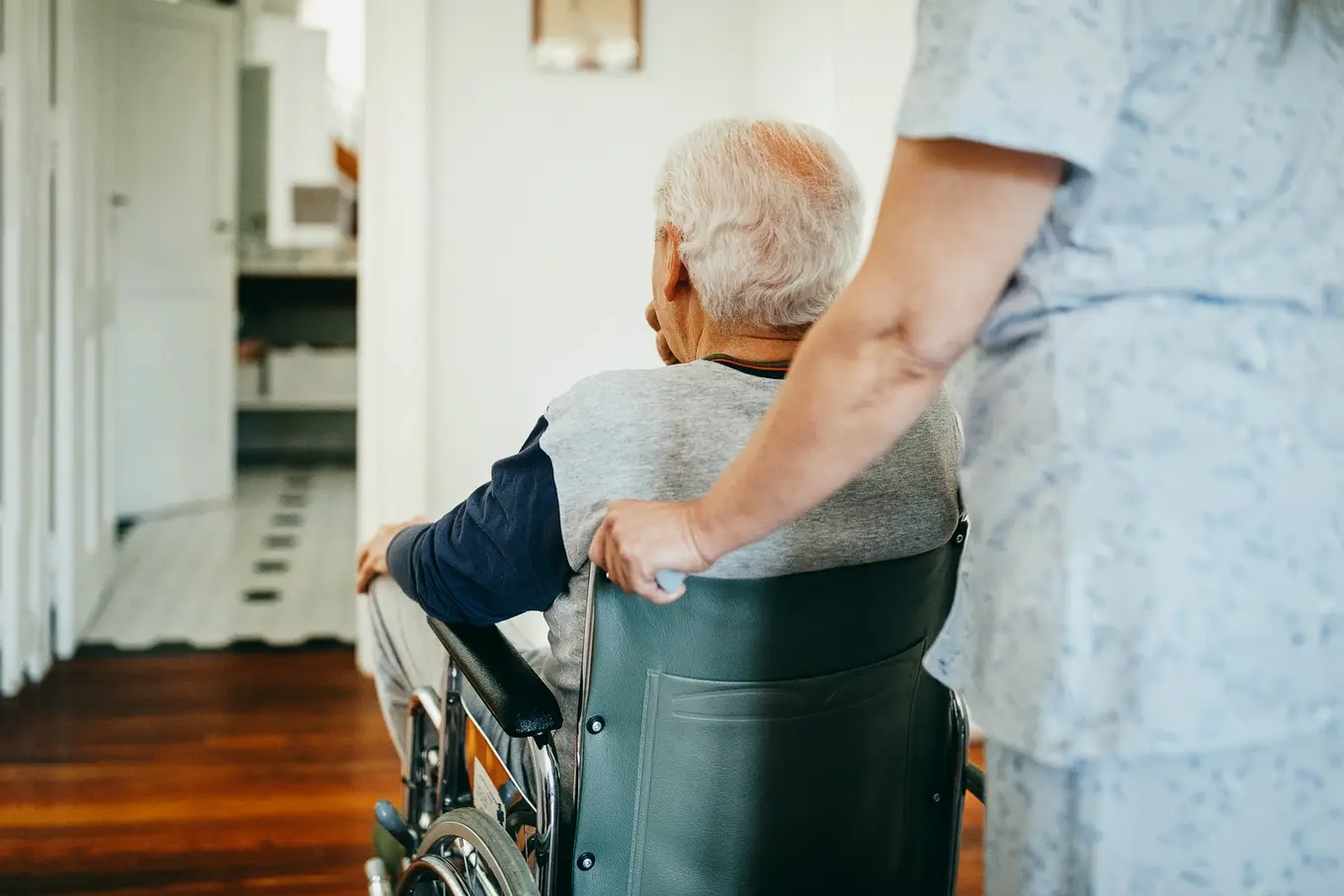 senior na wózku z pielęgniarką w domu opieki